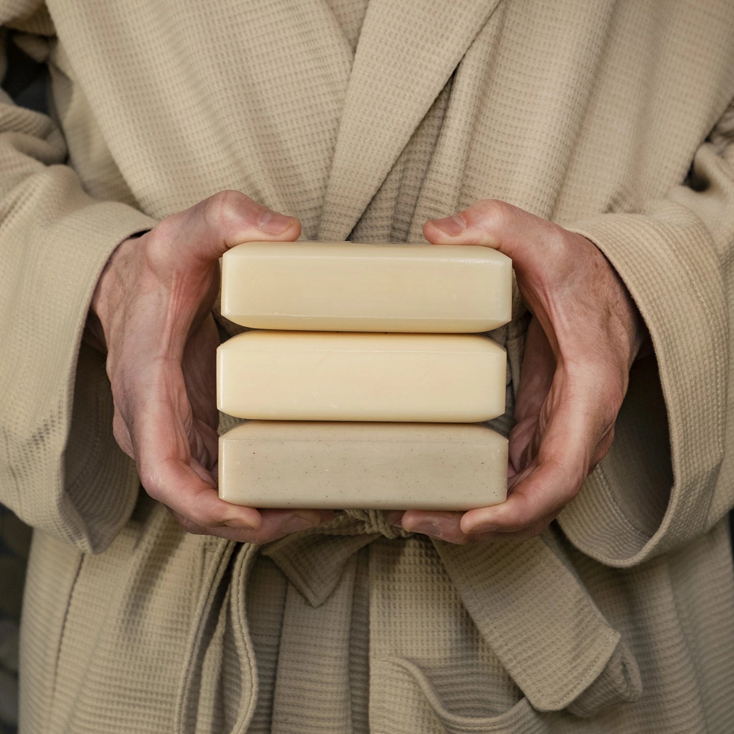Mans hands holding a stack of Man Bar soaps
