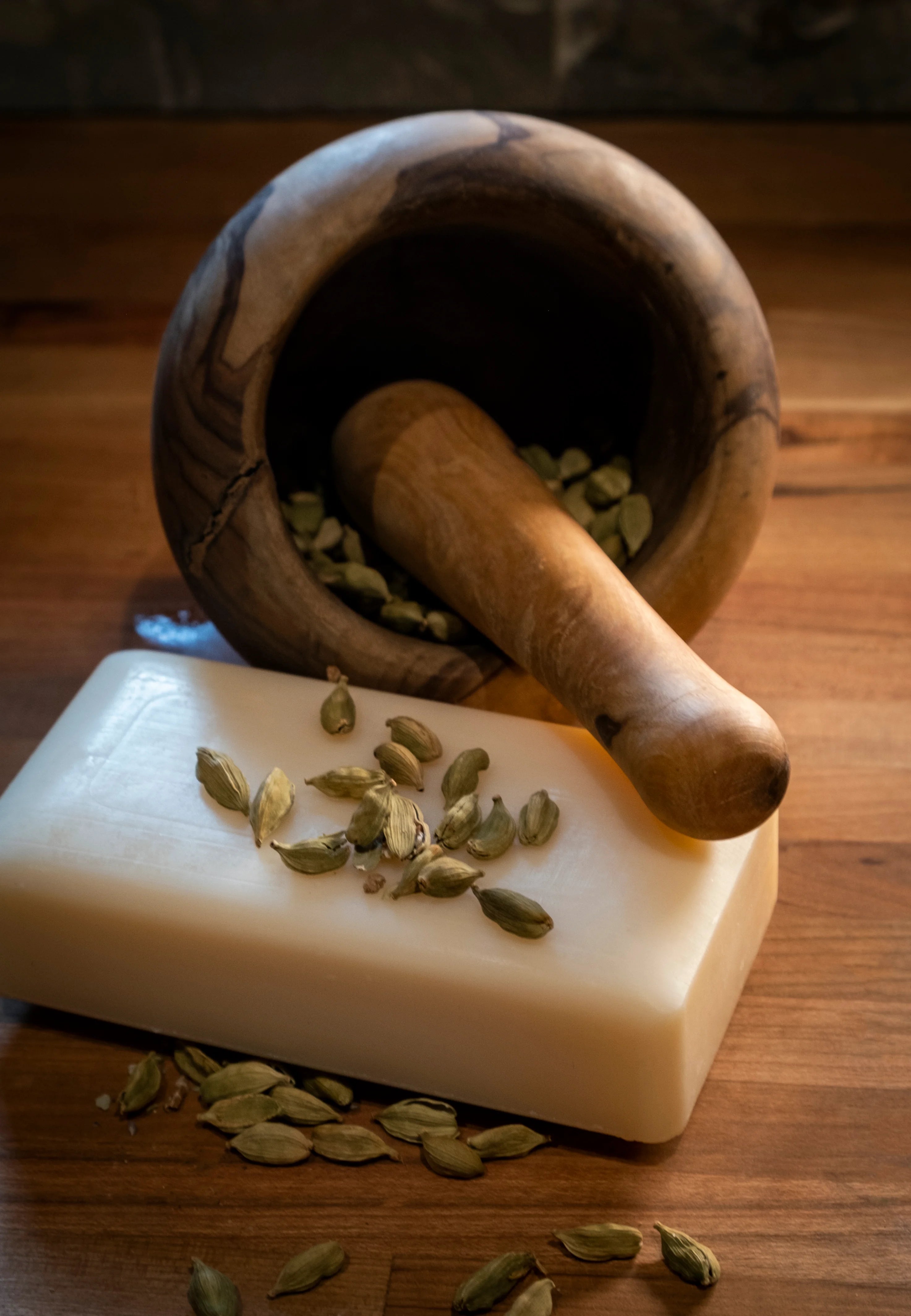 Man Bar soap with dried cardamom and a mortar with pestle