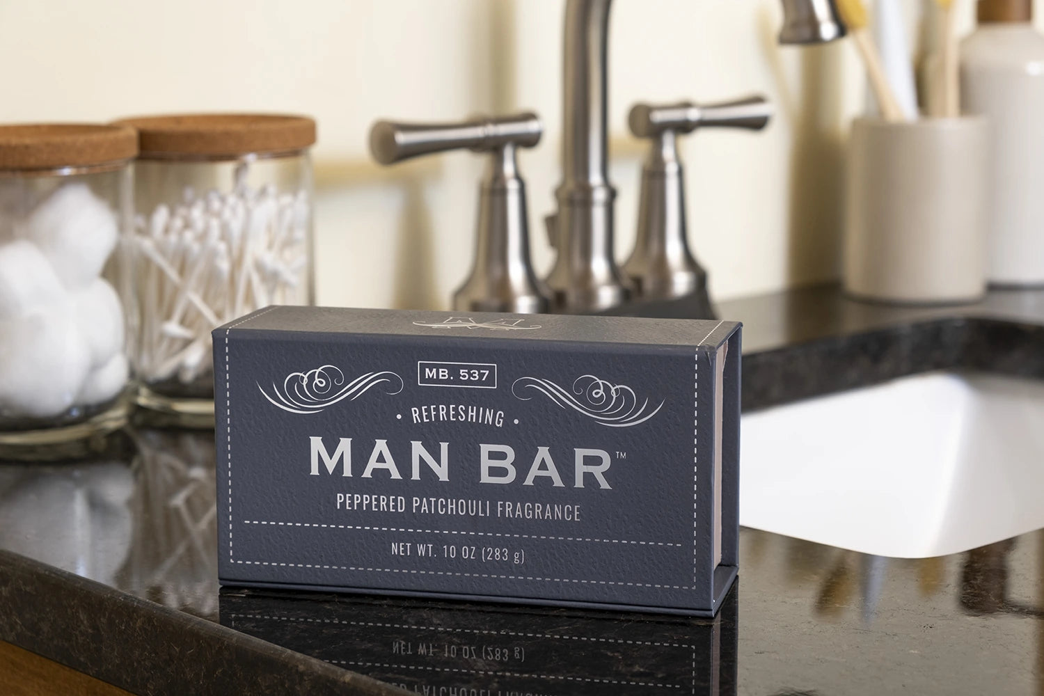 Man Bar Peppered Patchouli box resting on a bathroom sink counter
