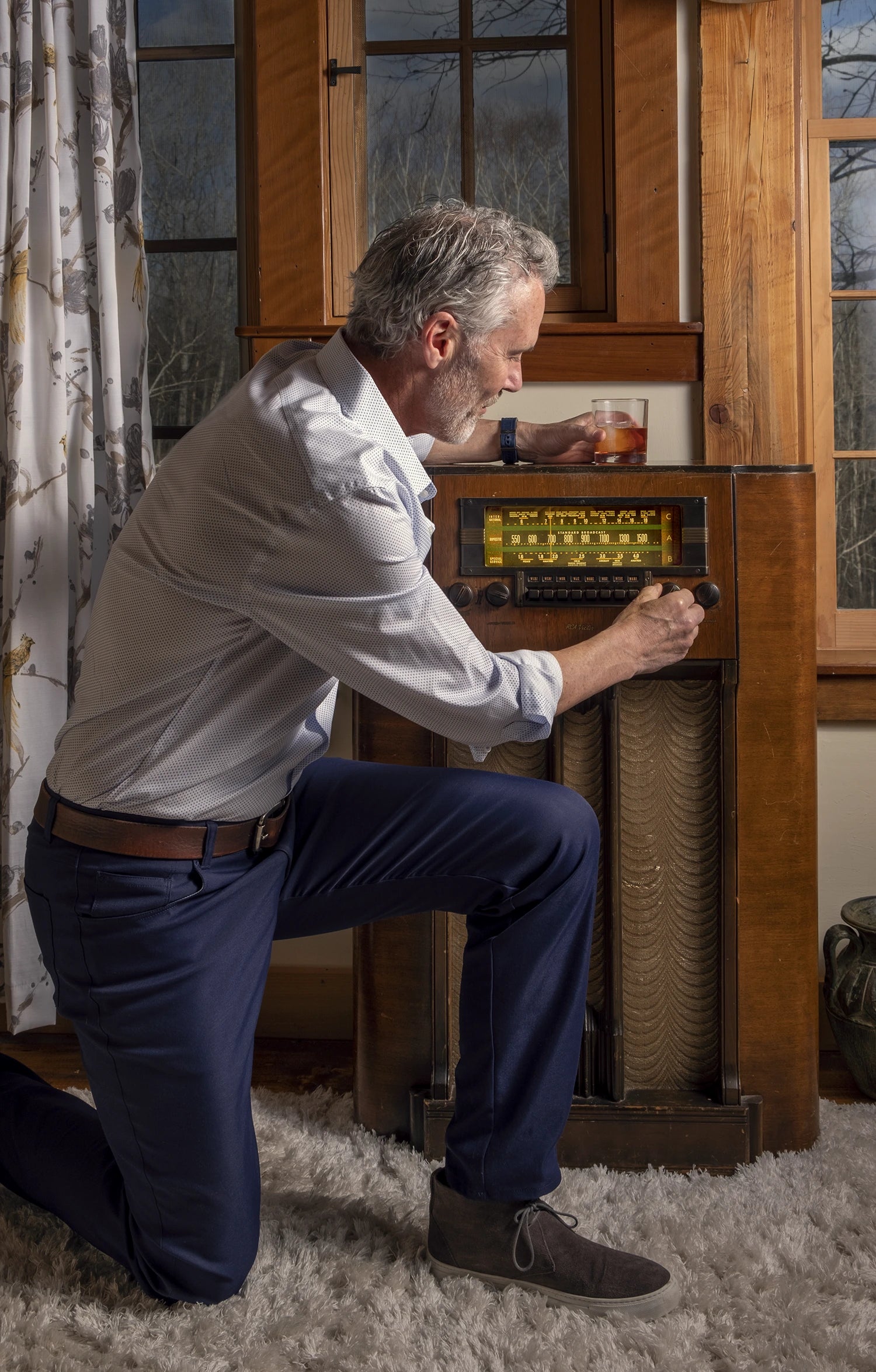 Male model tuning a large antique radio